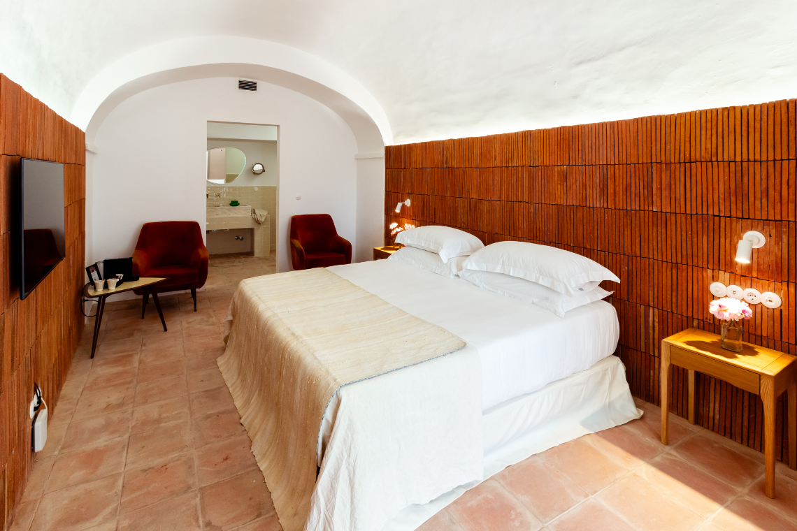 a bedroom with two chairs and a flat screen tv