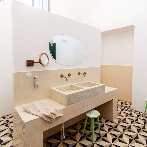 un baño con dos lavabos y un espejo