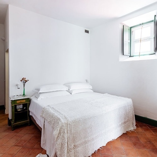 una habitación con una cama y una ventana con persianas verdes