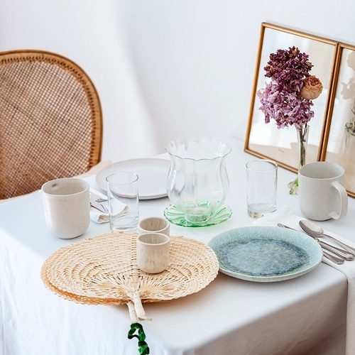 una mesa con platos y vasos y un ventilador encima