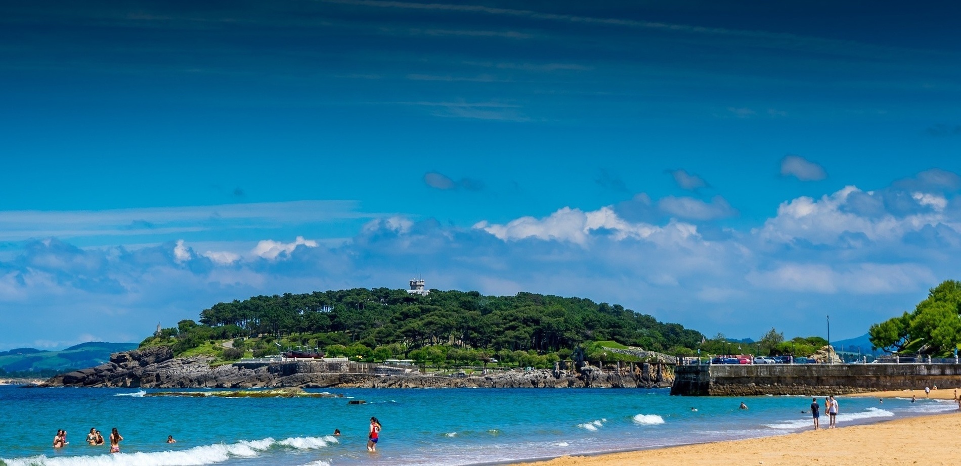 a beach scene with a small island in the background