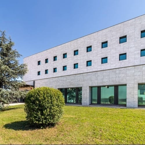 a building with a lot of windows and a tree in front of it