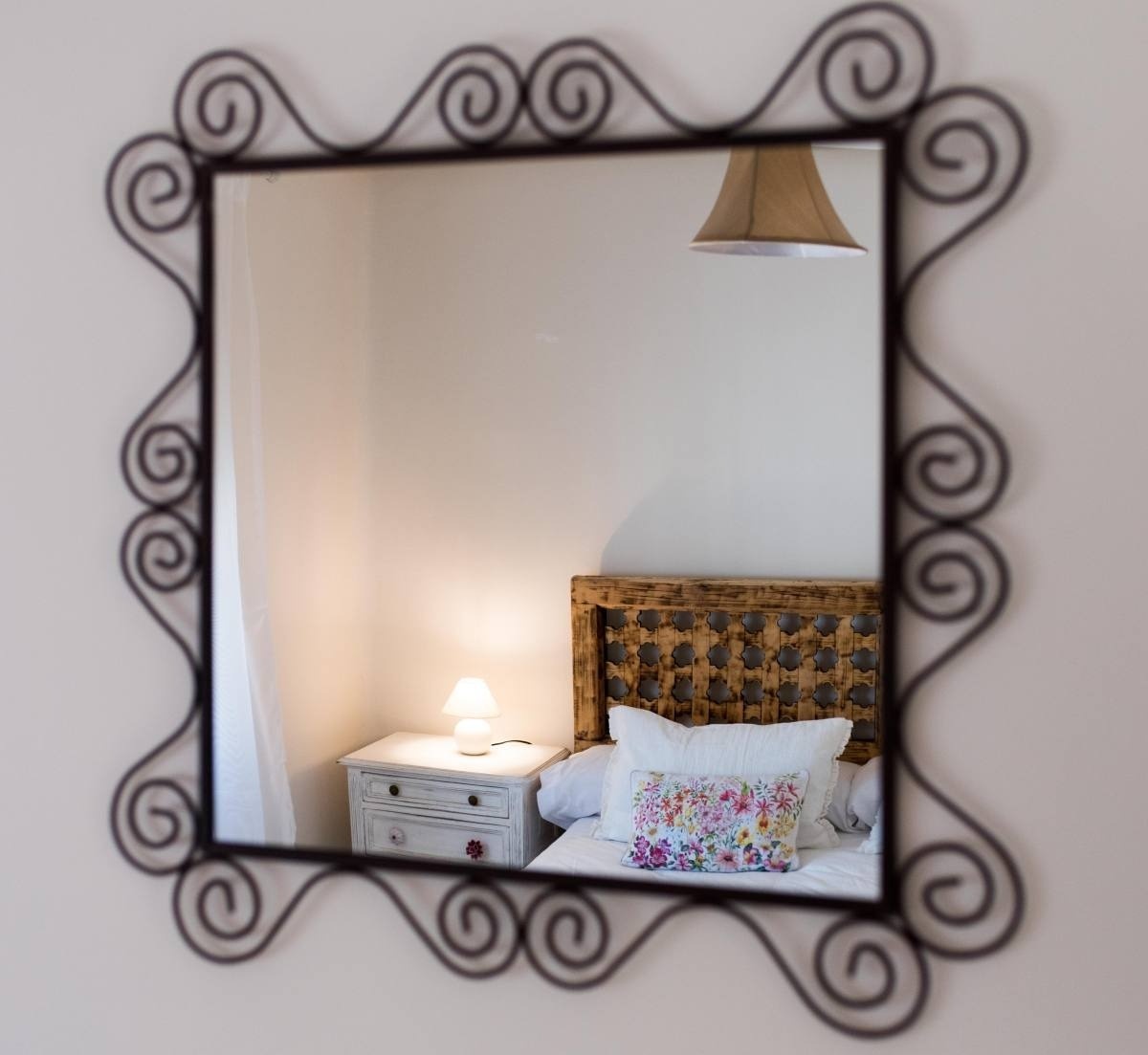 a bedroom with a bed and a mirror with swirls on it