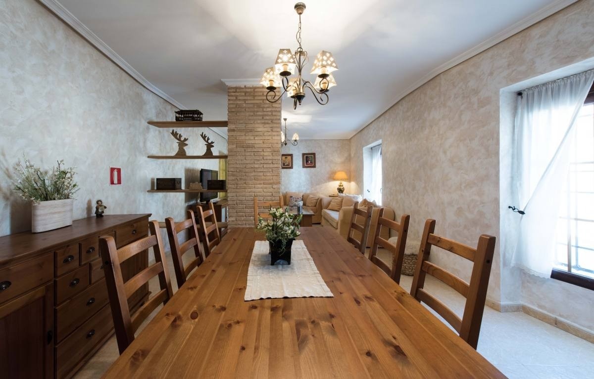 a dining room with a long wooden table and chairs