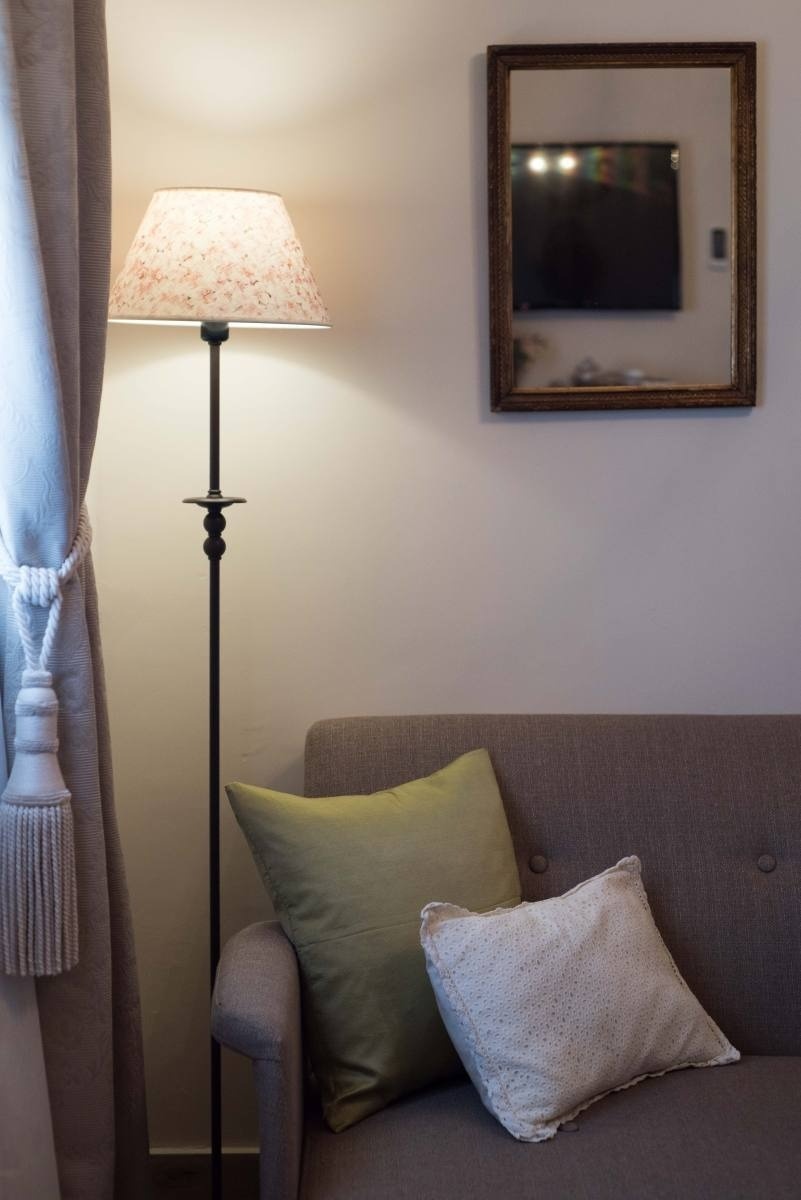 un sofá con dos almohadas y una lámpara de pie