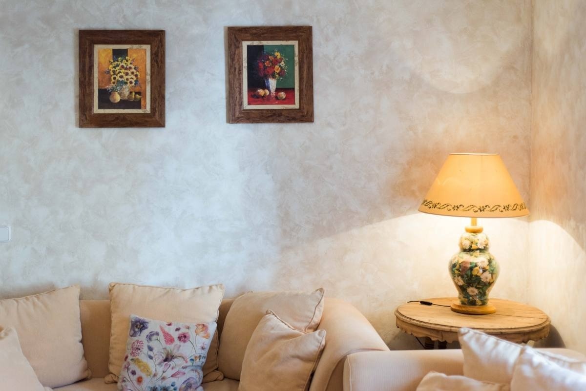 un sofá y una lámpara en una habitación con dos cuadros en la pared