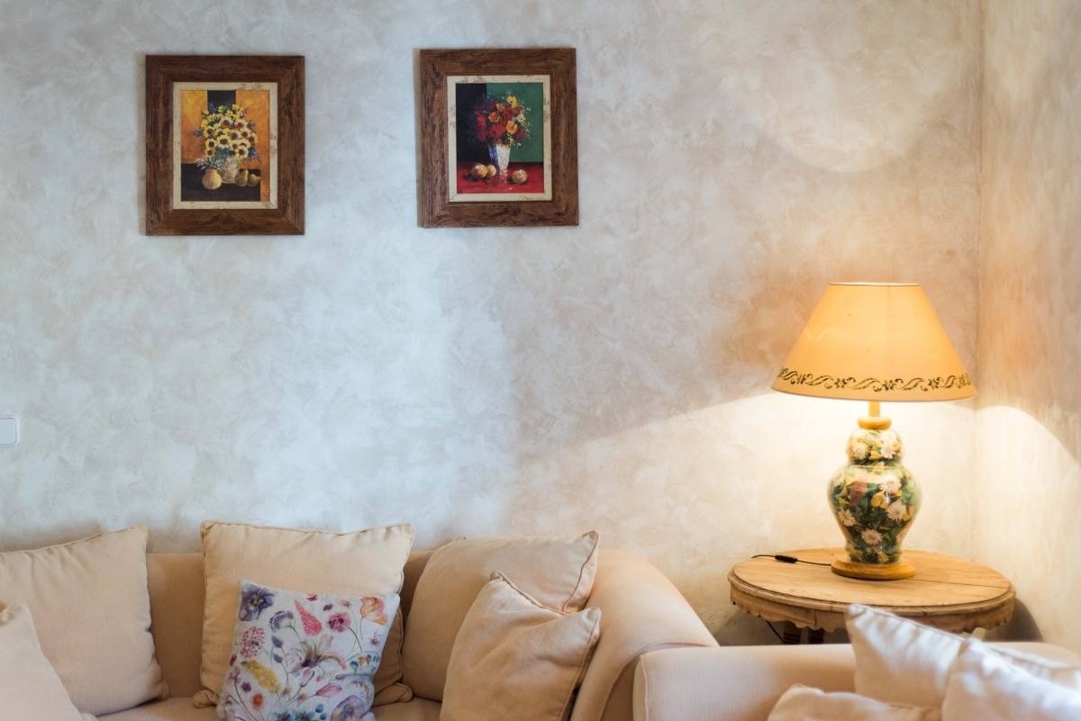 a living room with a lamp and two paintings on the wall