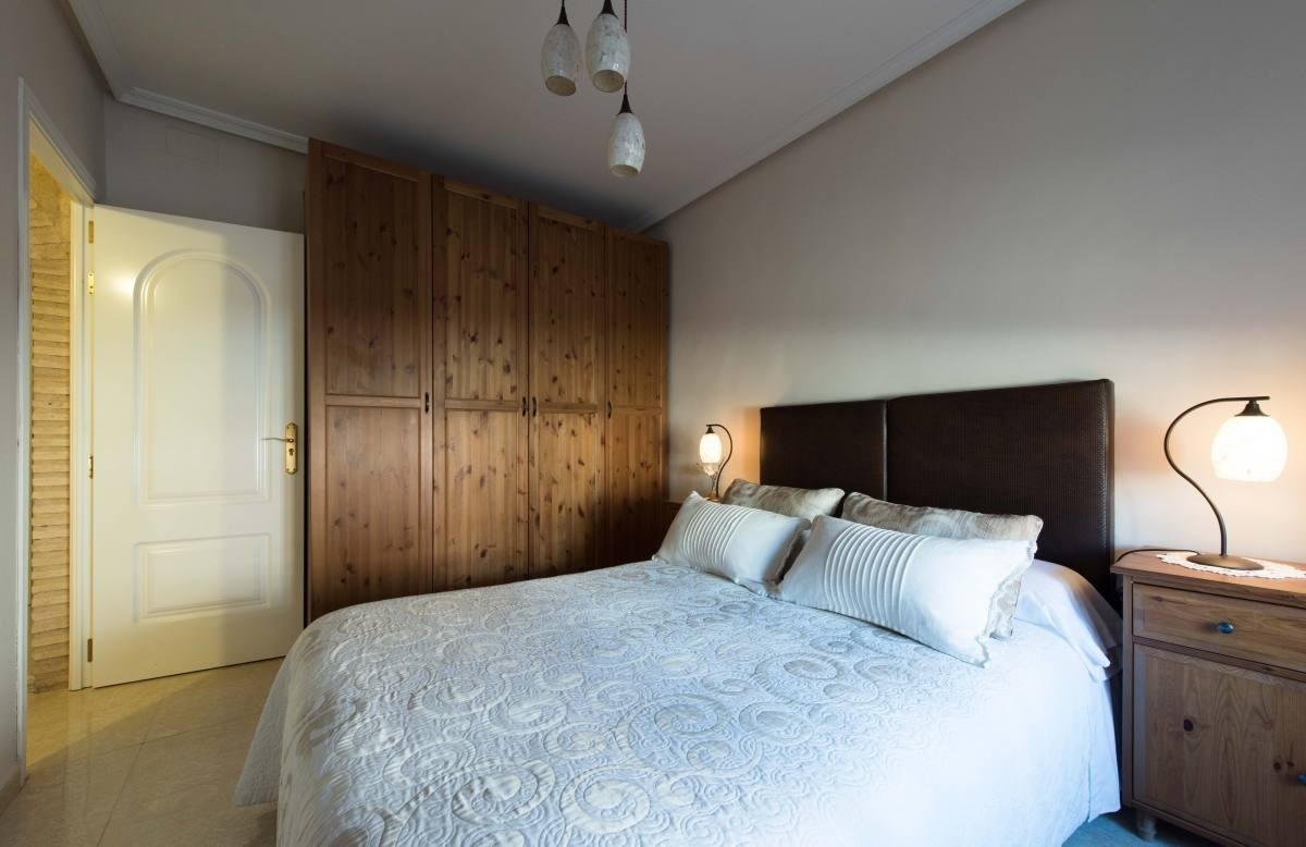 un dormitorio con una cama y un armario de madera