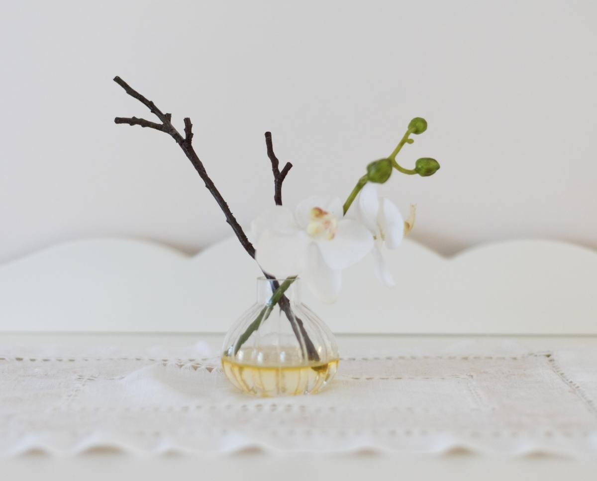 a small glass vase with a white flower in it