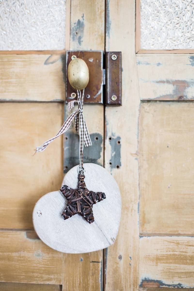 un corazón de madera con una estrella colgando de una puerta de madera