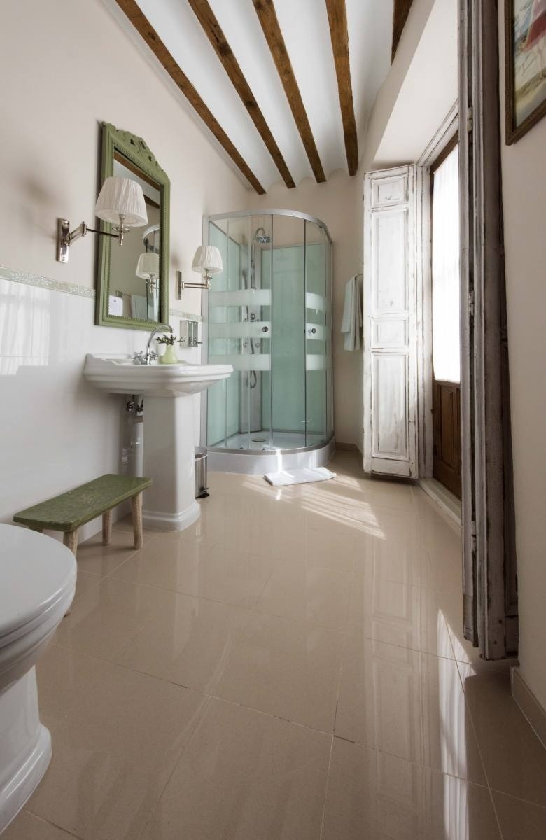 a bathroom with a pedestal sink and a walk in shower