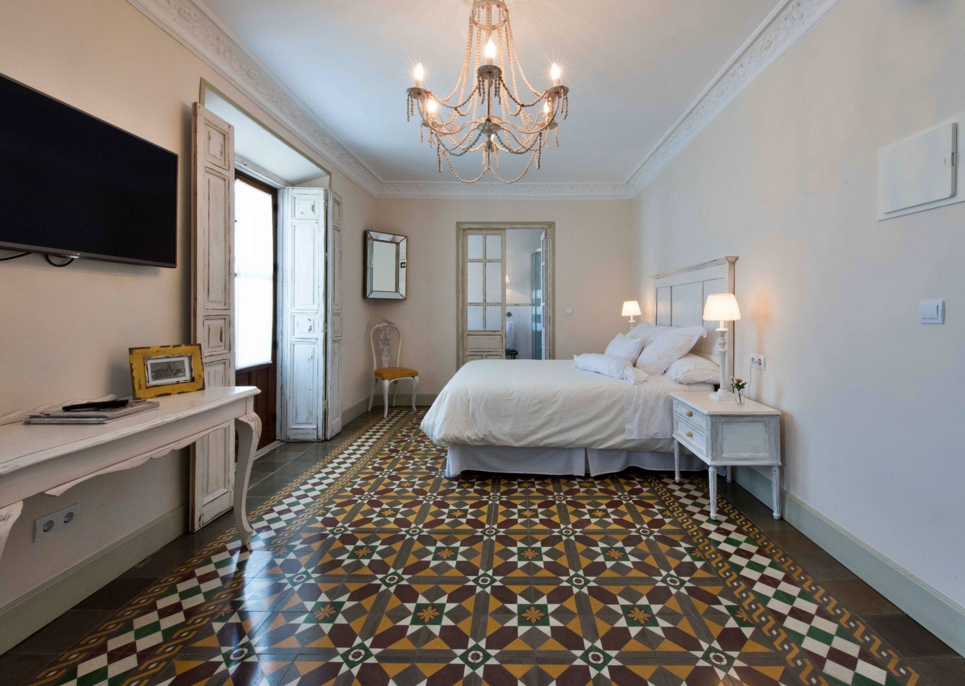 a bedroom with a chandelier hanging from the ceiling