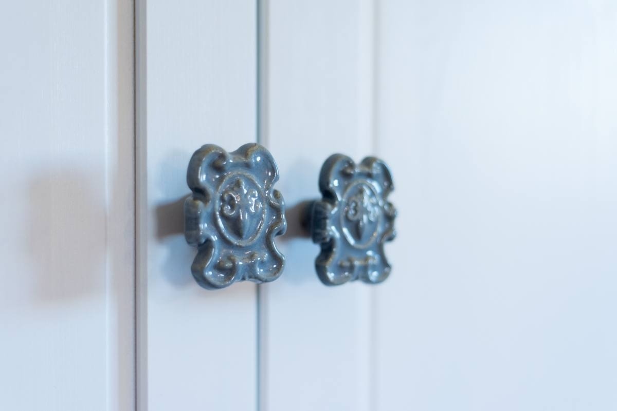 a close up of a cabinet with a floral design on the handles