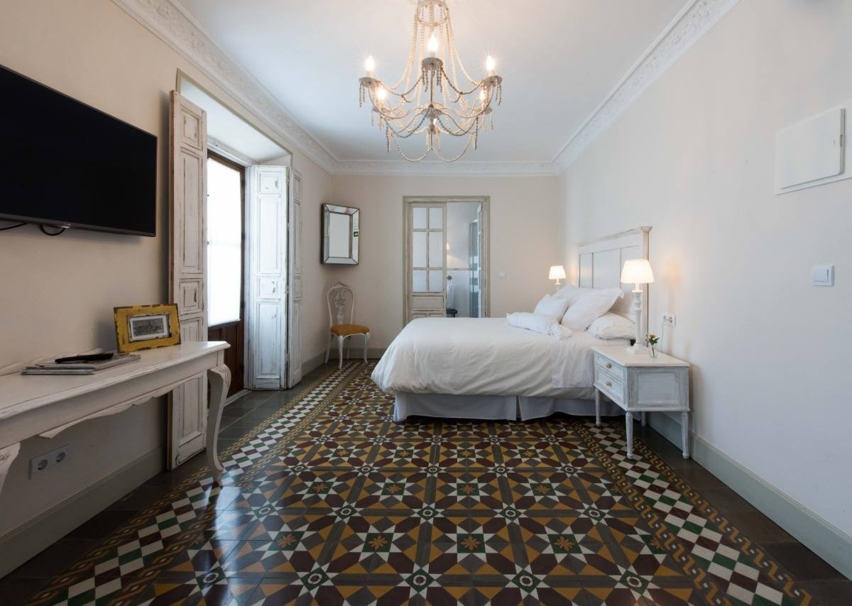 a bedroom with a large bed and a chandelier