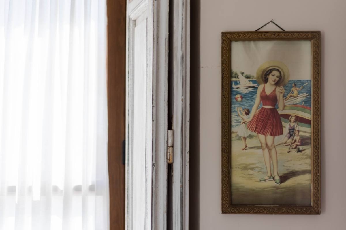 una pintura de una mujer con un vestido rojo está colgada en una pared