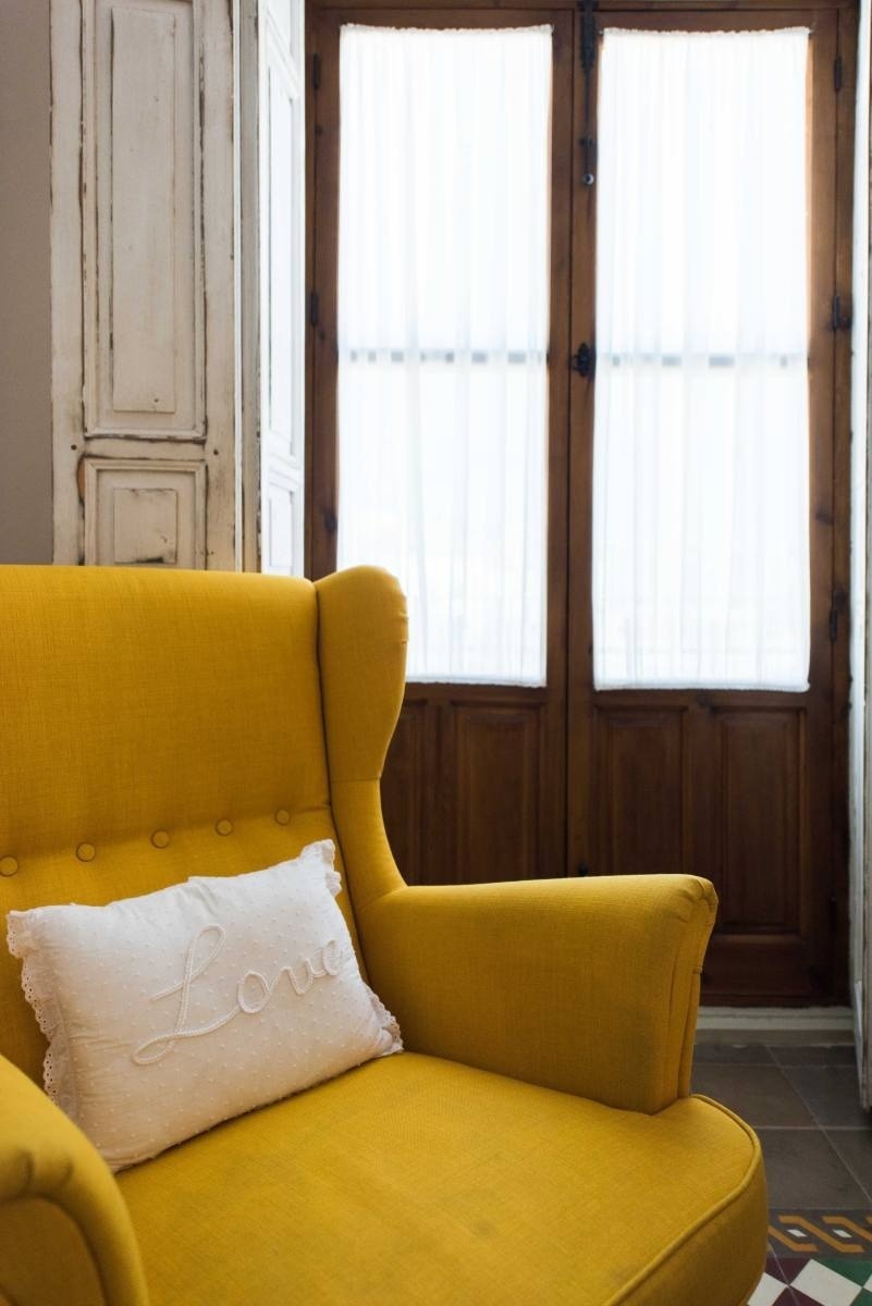 una silla amarilla con una almohada blanca que dice love