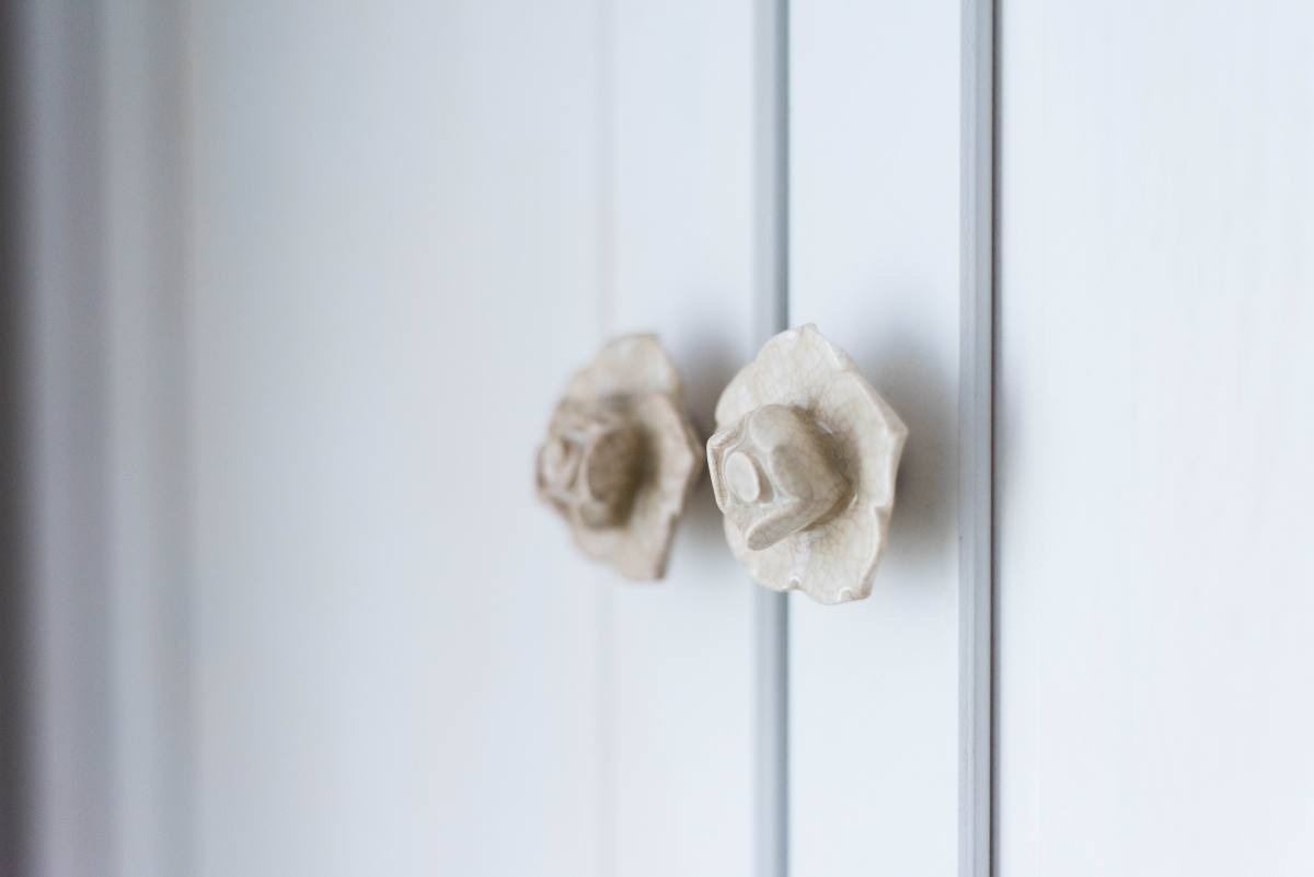 a white cabinet with two knobs that look like flowers