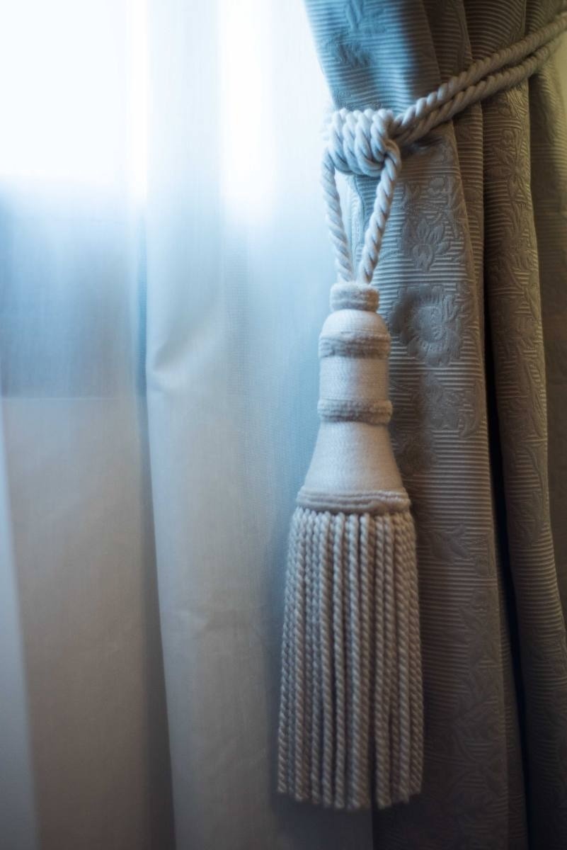 una cortina con una borla blanca atada a ella