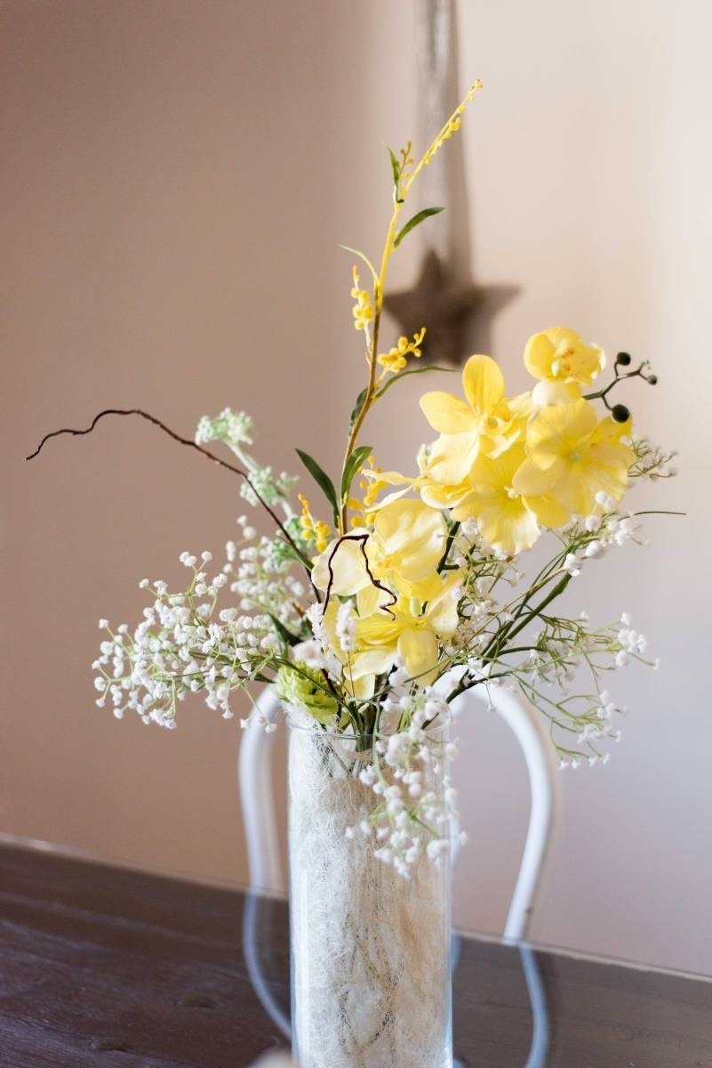 a vase filled with yellow flowers and baby 's breath