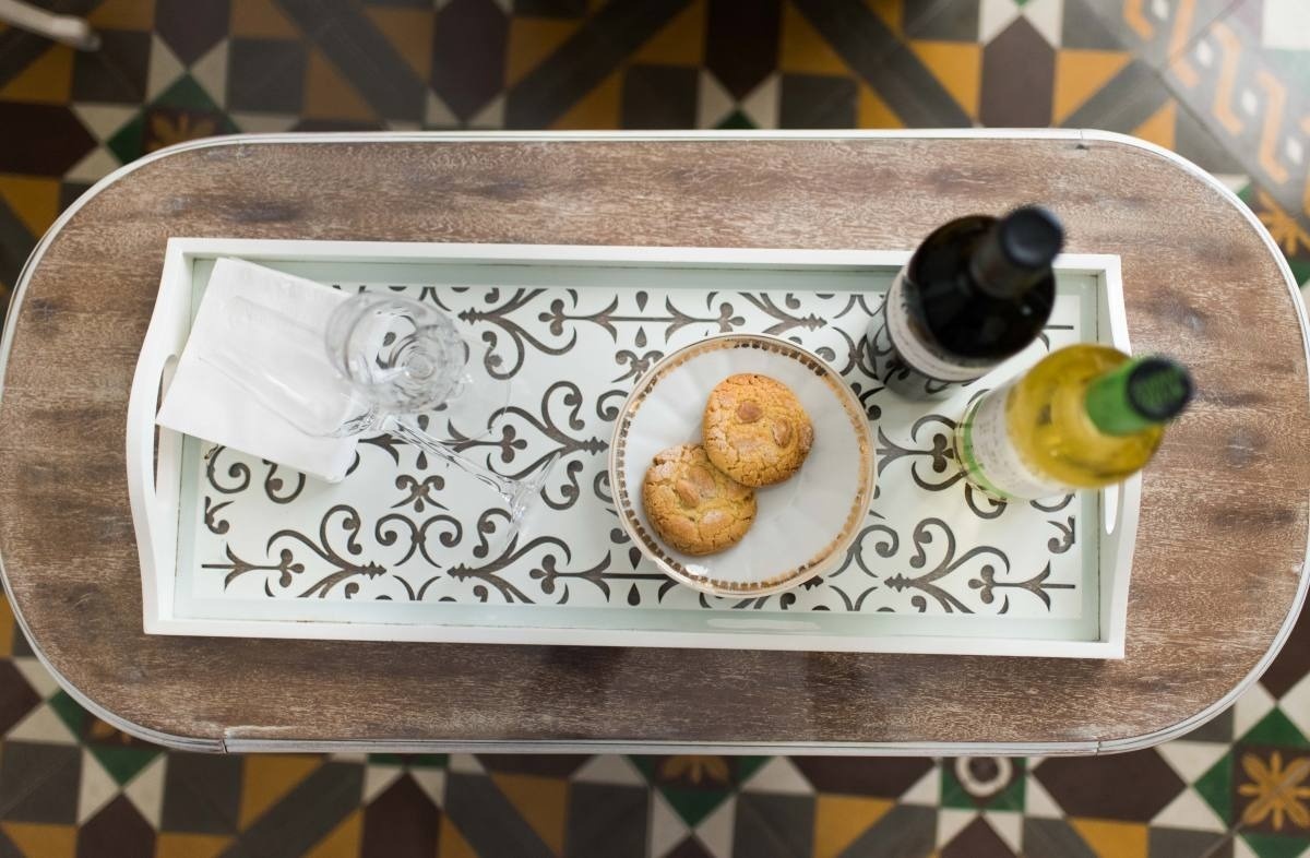 una bandeja de madera con galletas y botellas de vino