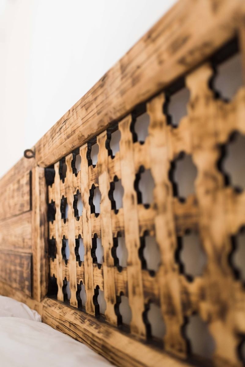 a close up of a wooden railing with holes in it