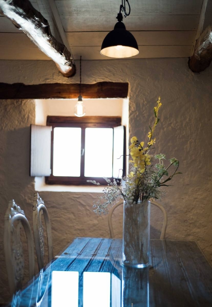 a vase of flowers sits on a table in front of a window