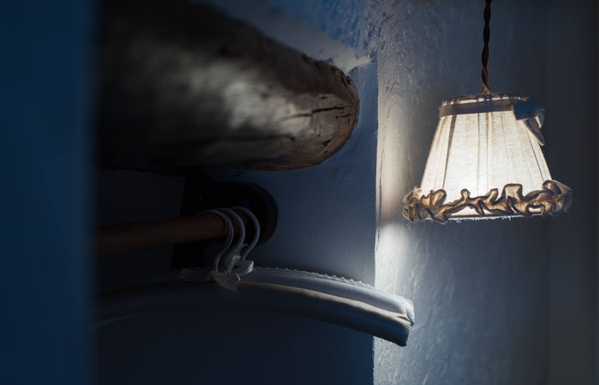 a lamp hanging on a wall next to a clothes rack