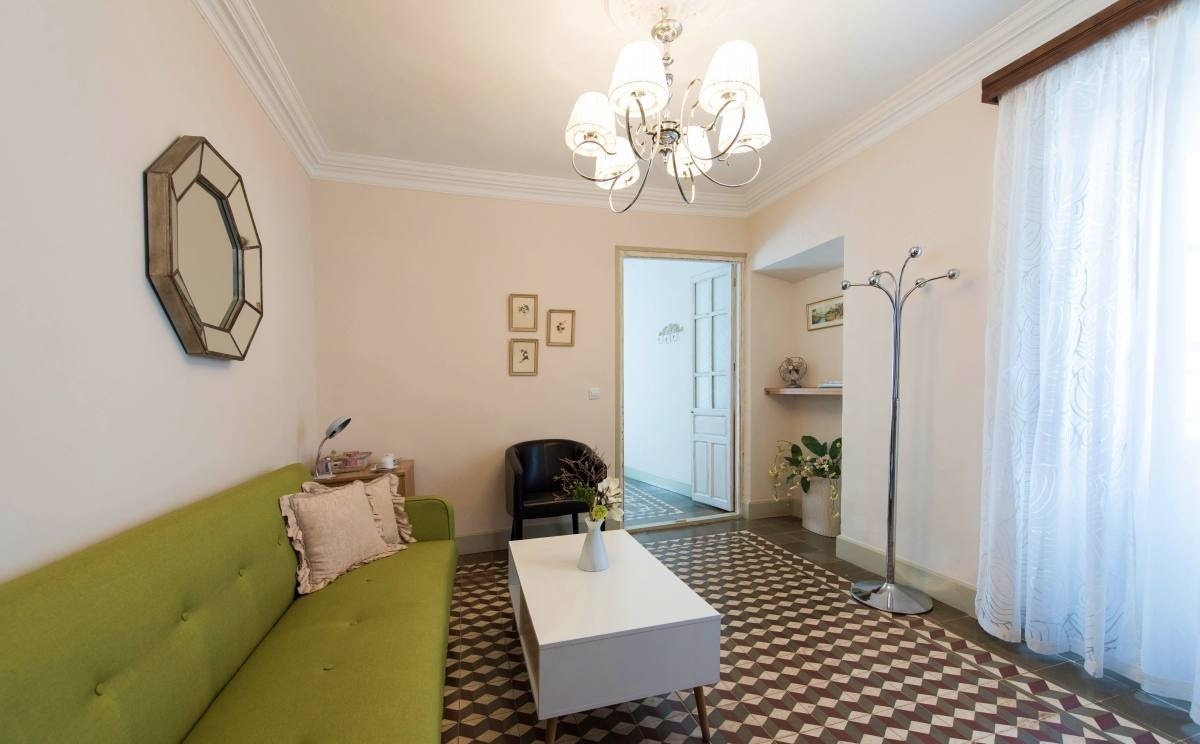 a living room with a green couch and a white coffee table