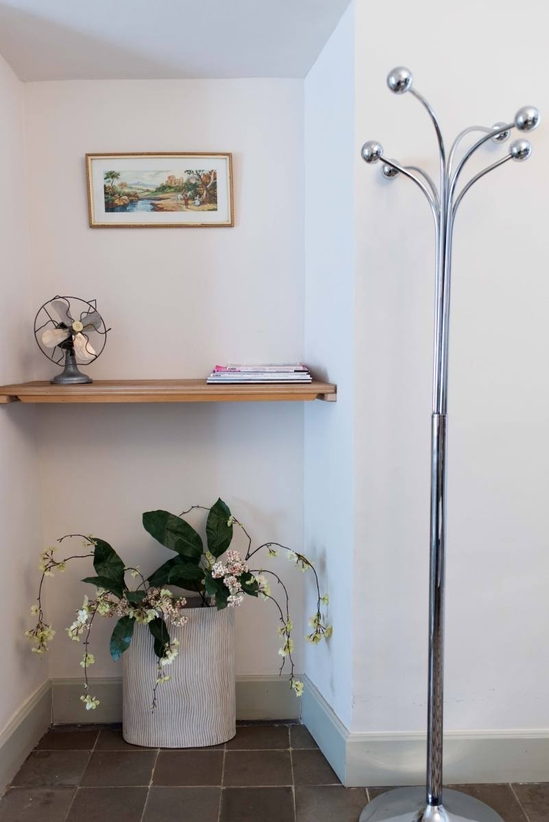 a corner of a room with a plant and a fan