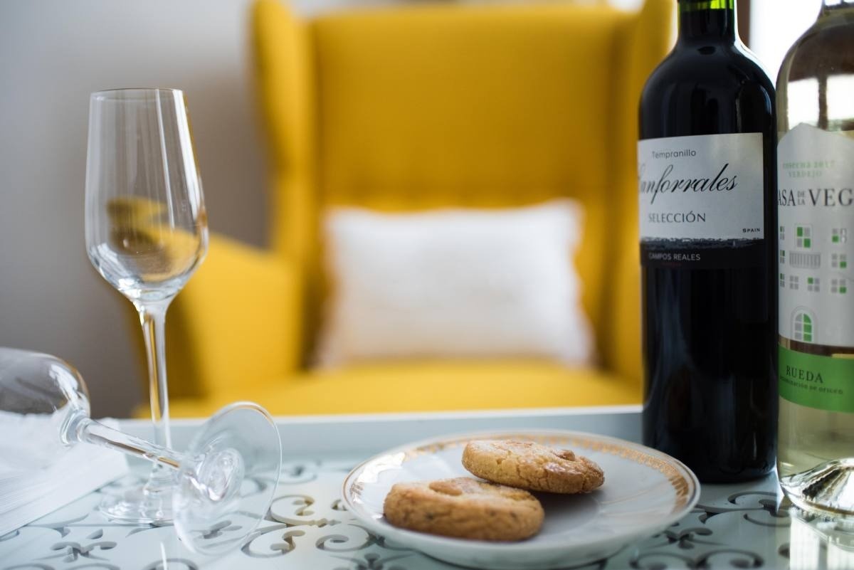 una mesa con una botella de vino y un plato de galletas