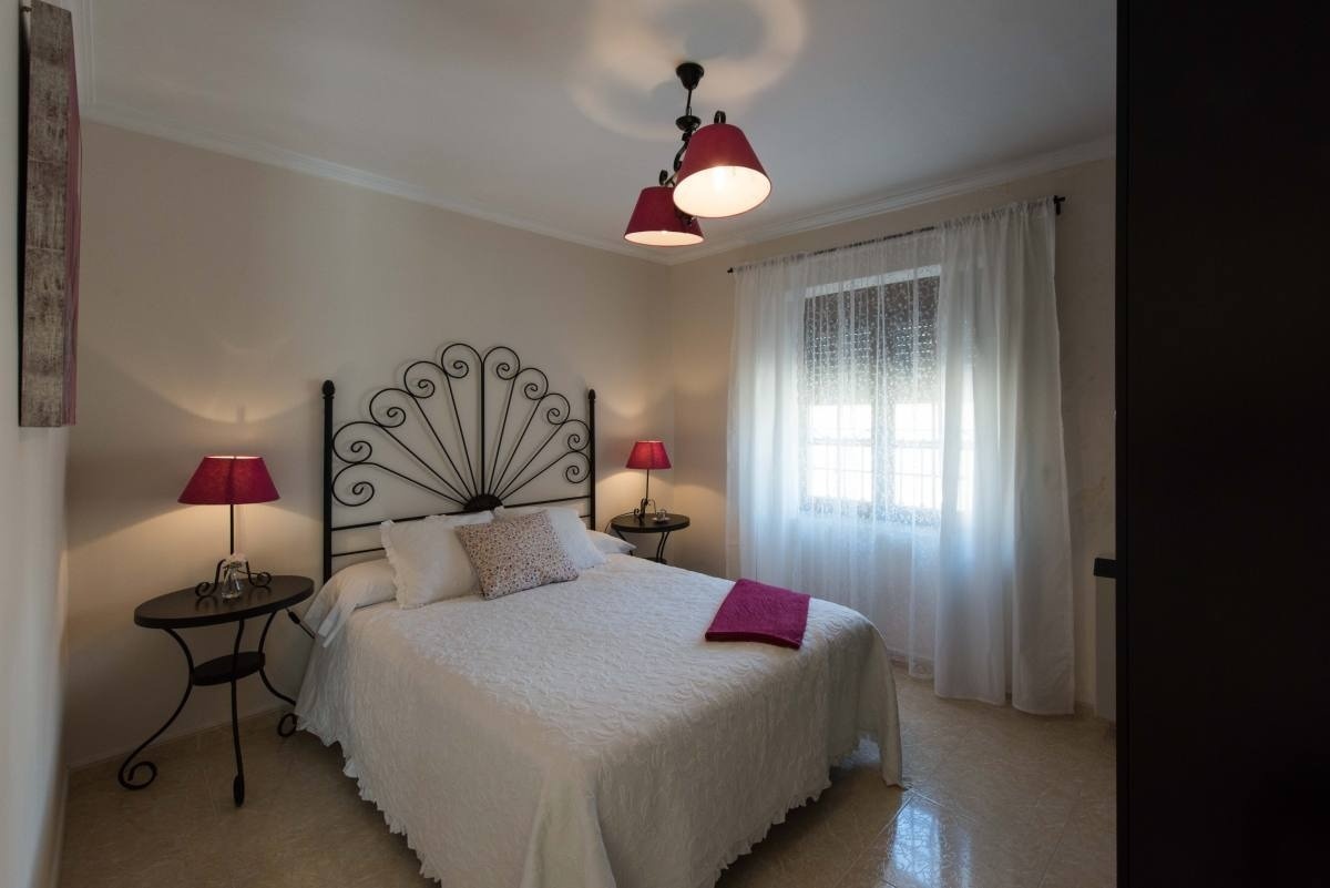 a bedroom with a wrought iron headboard and two lamps