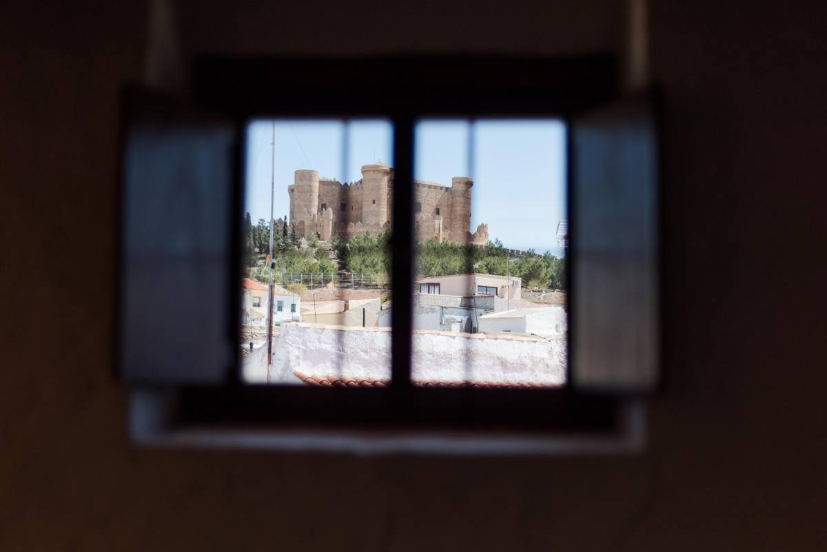 a view of a castle through a window with shutters