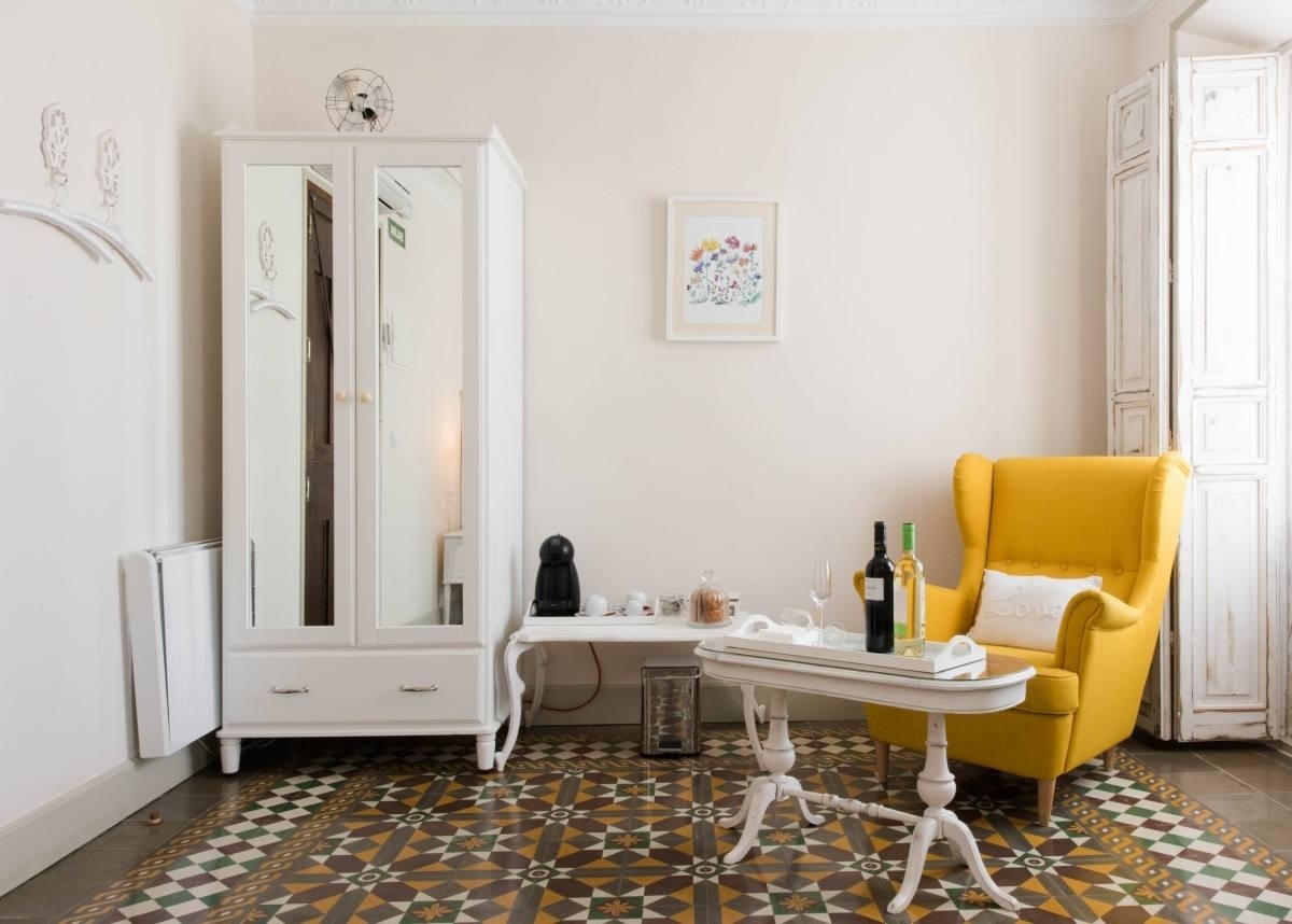una habitación con una silla amarilla y dos botellas de vino