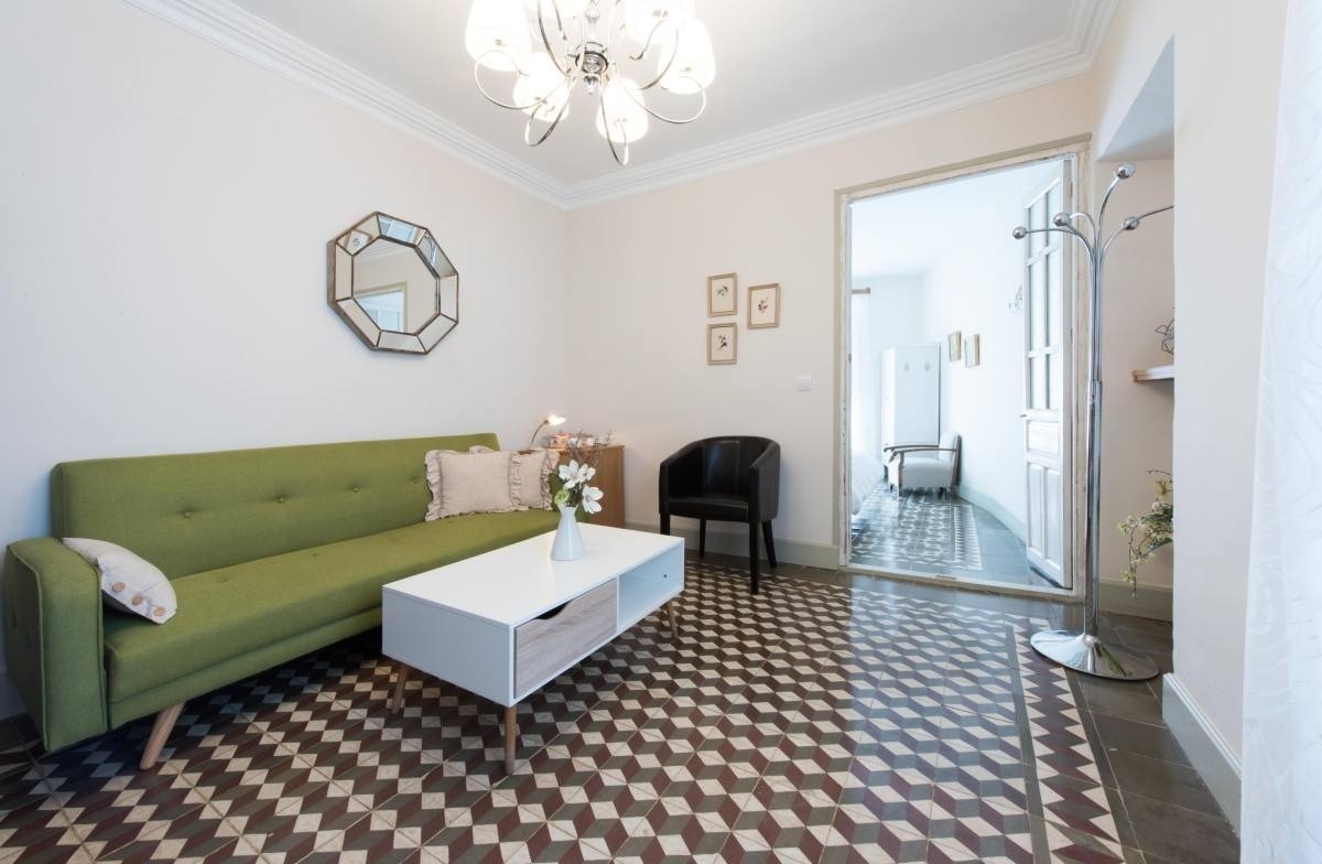 a living room with a green couch and a white coffee table