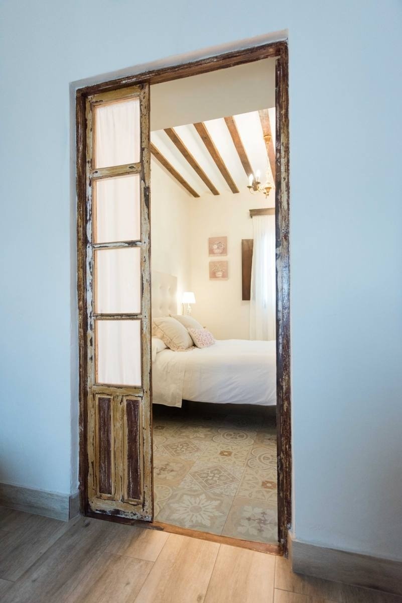 a bedroom with a sliding glass door leading to a bed