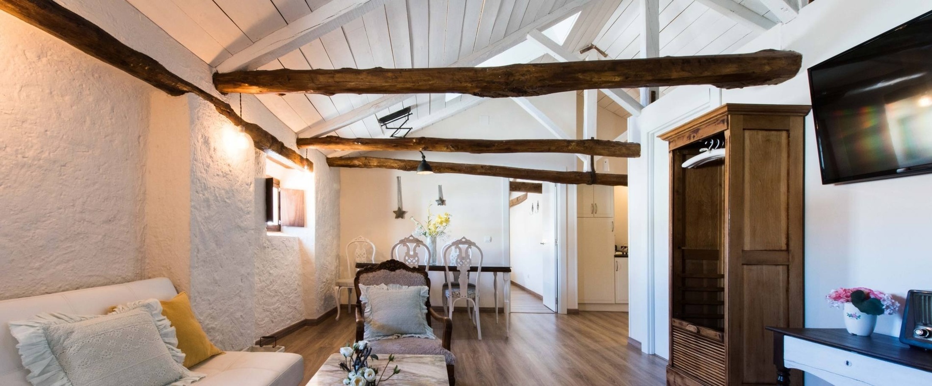 a living room with wooden beams and a flat screen tv