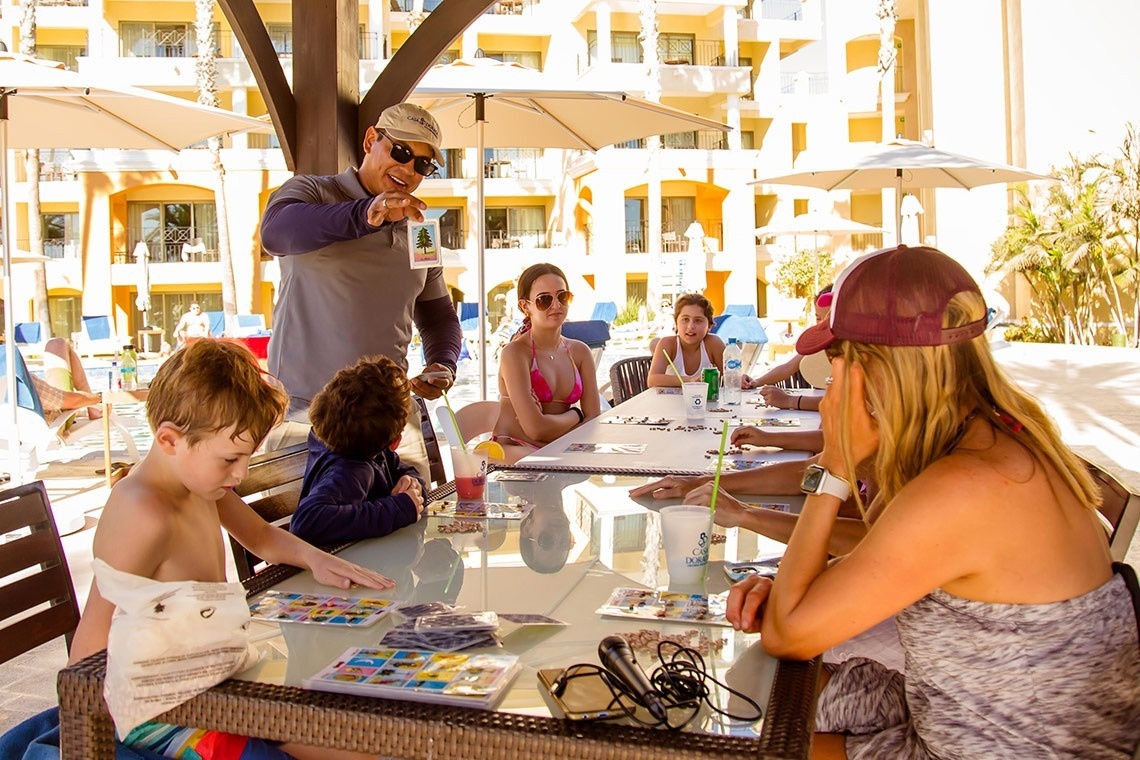 a group of people are sitting around a table playing a game