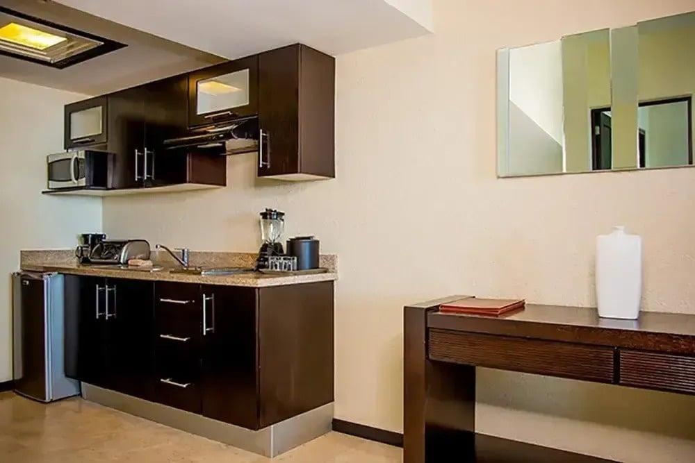 eine kleine Küche mit braunen Schränken und einem Kühlschrank