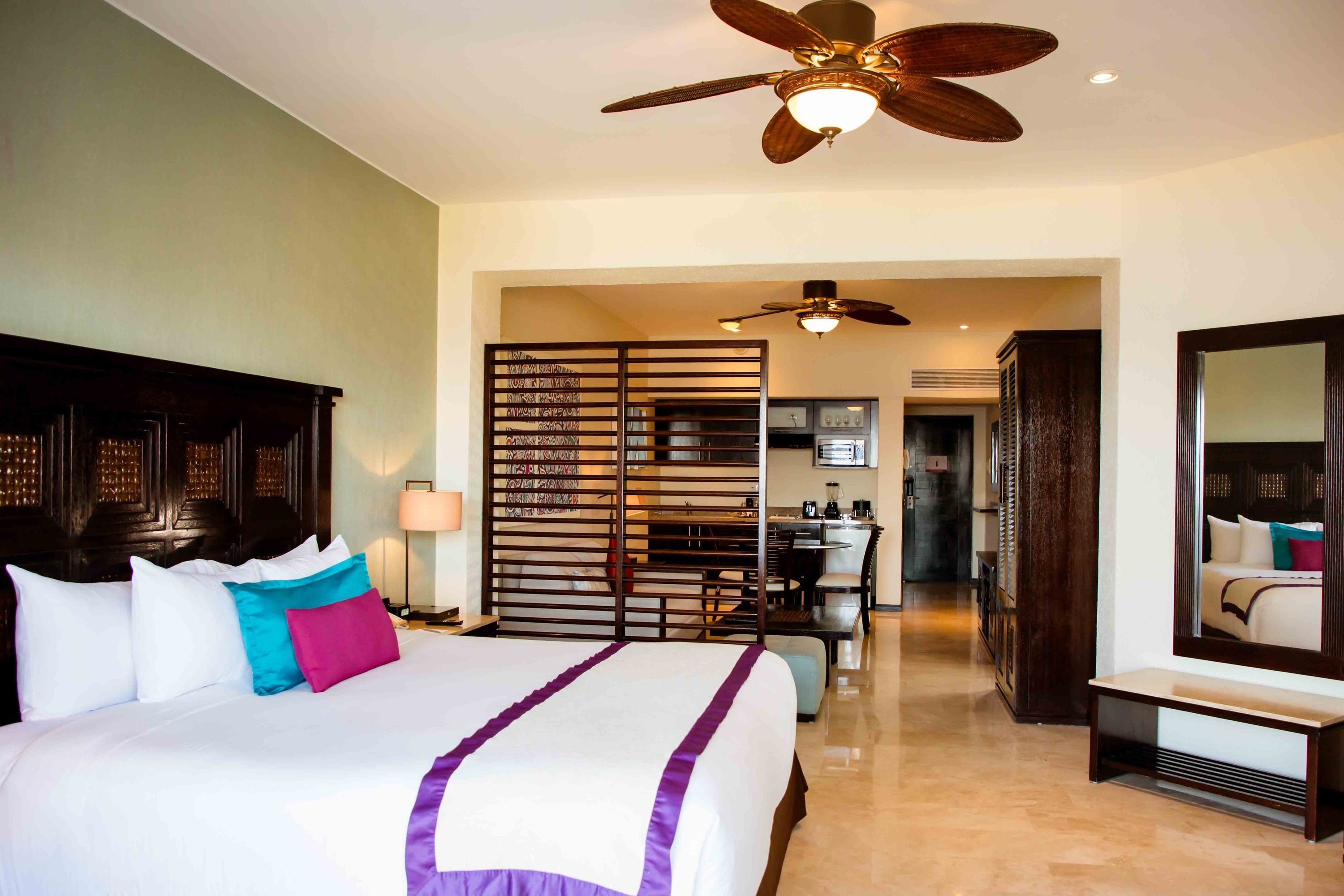 ein Hotelzimmer mit einem Bett und einem Deckenventilator