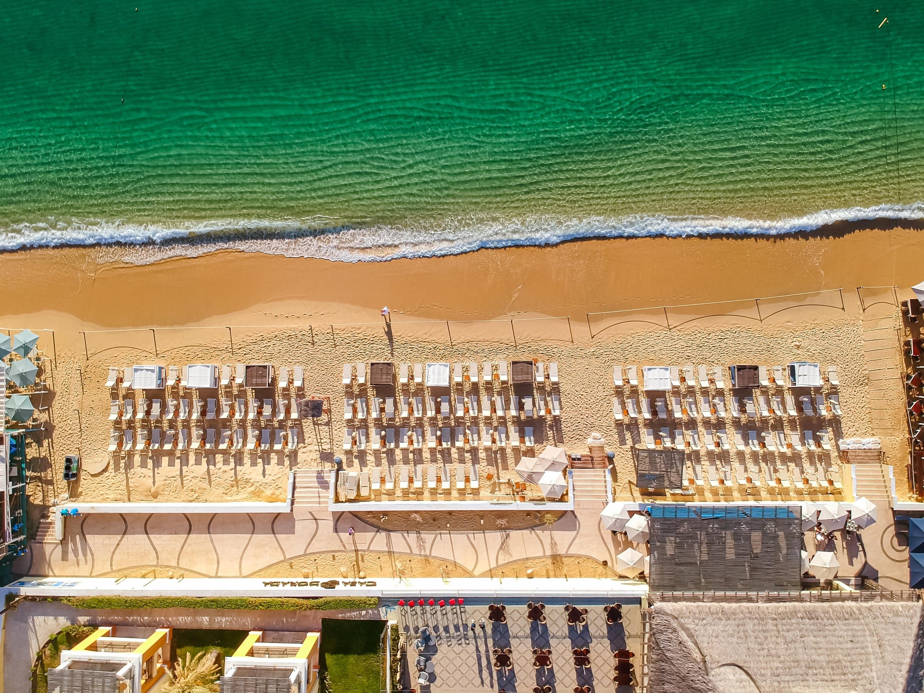 dos mujeres sostienen bebidas en la playa