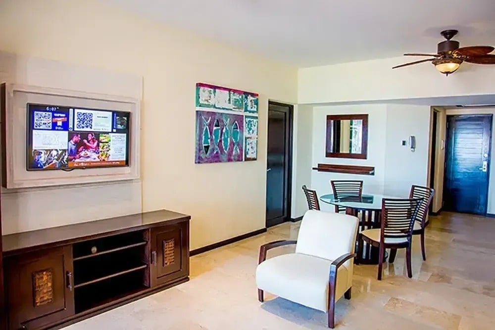 ein Wohnzimmer mit einem Fernseher und einem Esstisch