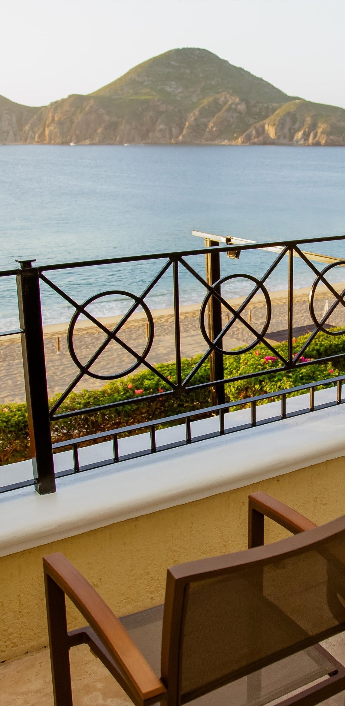 a view of the ocean from a balcony with a wrought iron railing