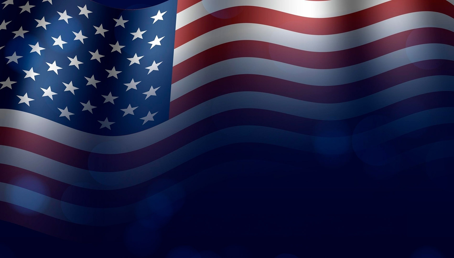 eine amerikanische Flagge weht im Wind auf einem dunkelblauen Hintergrund