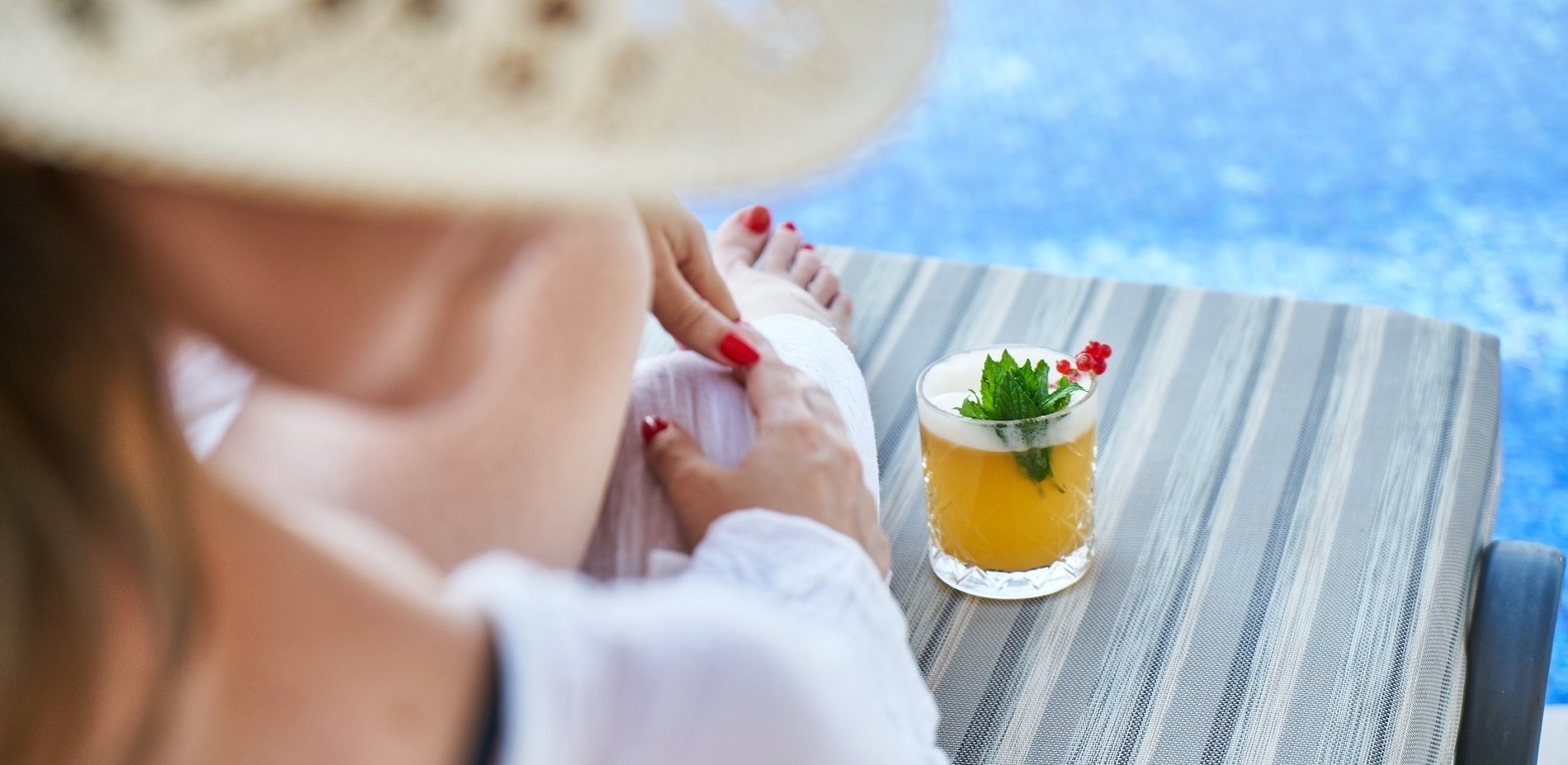 Eine Frau sitzt auf einem Stuhl neben einem Cocktail
