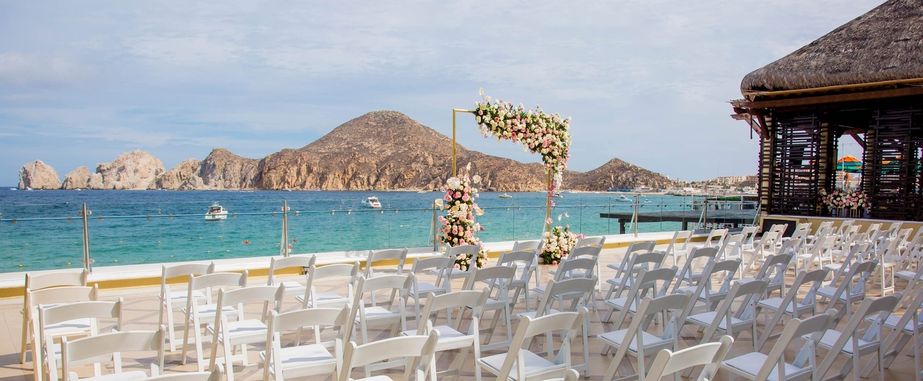 rows of white chairs are set up for a wedding ceremony overlooking the ocean