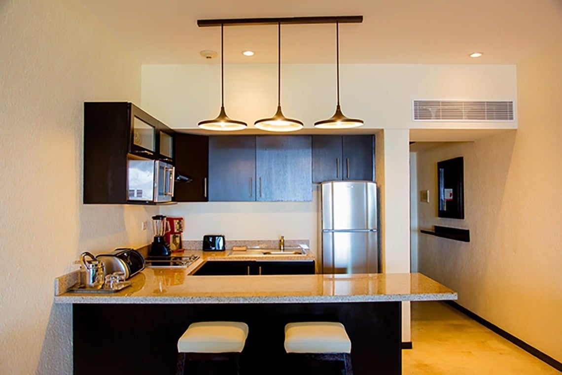 eine kleine Küche mit einem Kühlschrank und einer Mikrowelle