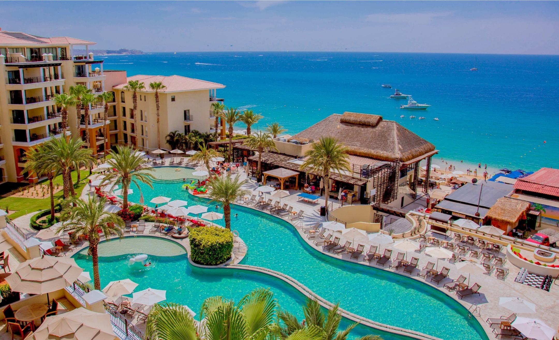 una gran piscina rodeada de palmeras en un resort