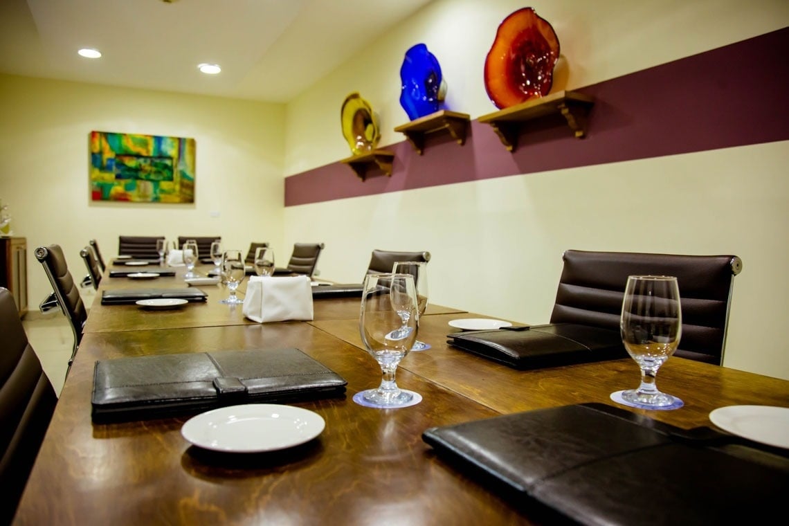 ein Konferenzraum mit einem Tisch und Stühlen und einem Gemälde an der Wand