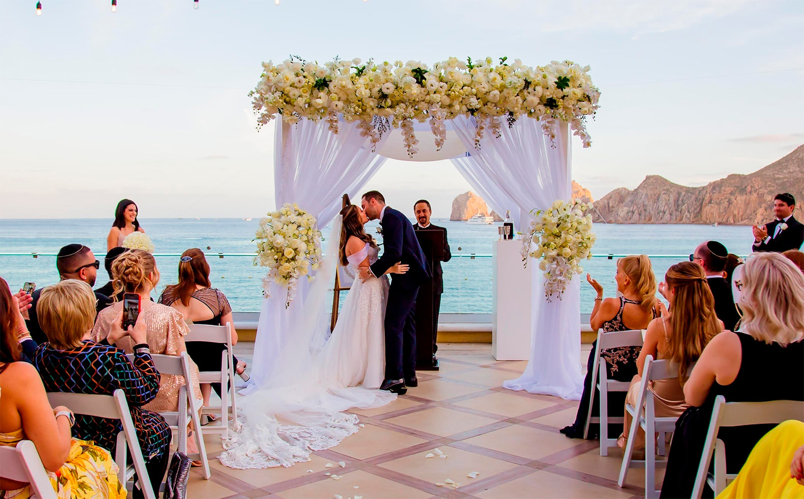 Mariage à la Casa Dorada : couple s'embrassant sous arche florale