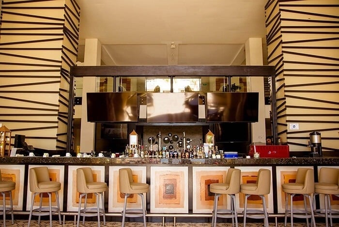 un bar lleno de botellas y sillas en un restaurante